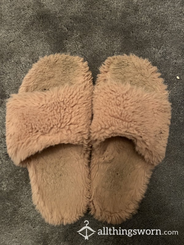 Worn Pink Fluffy Slippers With Footprints